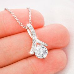 Melt her heart with this ALLURING BEAUTY necklace gift! The petite ribbon shaped pendant is finished with 14K white gold over stainless steel, and is embellished with dainty clear crystals surrounded by a sparkling 7mm round cut Cubic Zirconia. The adjustable cable chain allows the necklace to be worn at 18" to 22" in length. This necklace is one of our best sellers! Be sure to get yours NOW!Product Dimensions: • Height: 0.8" (20mm) x Width: 0.4" (10mm)• 7mm cubic zirconia • 18"-22" adjustable c Granddaughter Necklace, Bride Necklace, Wife Necklace, Beauty Necklace, Necklace Dress, Ribbon Necklace, Daughter Necklace, Biker Chick, Mors Dag