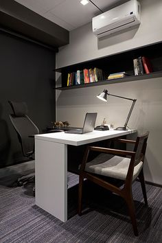 a desk with a laptop on it in front of a wall mounted air conditioner