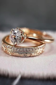 two gold wedding bands with a diamond ring in the middle and an engagement band on top