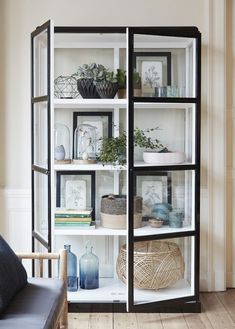 a black and white bookcase filled with lots of different types of things on top of it