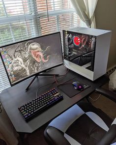 two computer monitors sitting next to each other on top of a desk in front of a window