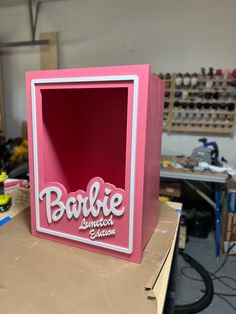 a pink box with the word barbie painted on it sitting on a workbench