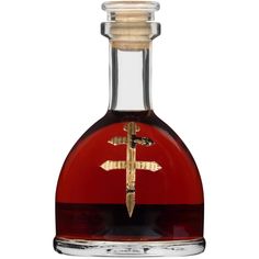 a glass bottle filled with red liquid and a gold cross on the top of it