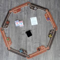 a wooden board game set up on top of a table with dices and other items