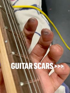 someone is playing an electric guitar with the words guitar scars