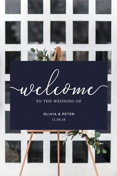 a welcome sign with greenery on top and the words welcome to the wedding of