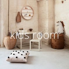 kids'room with white walls and black polka dots on the floor, wooden stools and small table