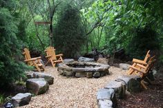 an outdoor fire pit surrounded by wooden chairs