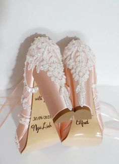 two pairs of wedding shoes with lace on the top and bottom, one is pink