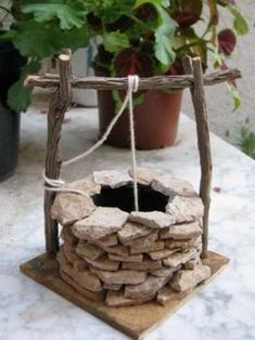 a stone fire pit sitting on top of a table next to a potted plant