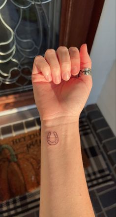 a woman's arm with a small tattoo on the left side of her wrist