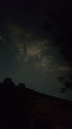 the night sky is dark and cloudy, with some clouds in the distance as well