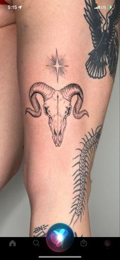 a woman's thigh with tattoos on it and an animal skull in the middle