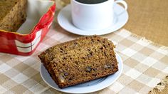 two slices of banana bread on a plate next to a cup of coffee