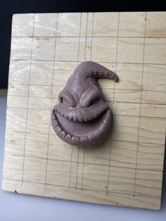 a wooden cutting board topped with a clay face