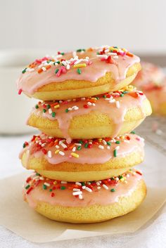 a stack of doughnuts with pink icing and sprinkles