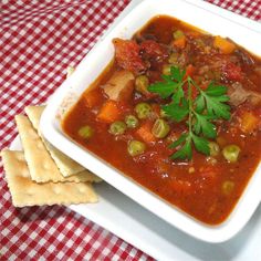 a white bowl filled with soup next to crackers