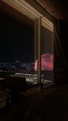 a window view of the city at night with red light on it's side