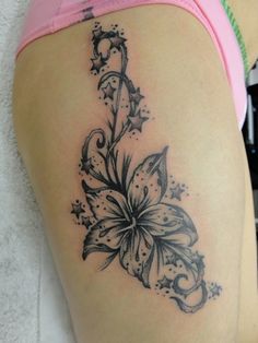 a woman's thigh with a flower tattoo on it