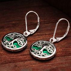 Shanore’s Green Malachite Sterling Silver Tree of Life Drop Earrings remind the wearer to grow inward and outward. Green malachite symbolizes positive change. Likewise, the Celtic Tree of Life stands for growth and good fortune. Thus, these Celtic earrings bring bliss and blessings. About this piece The Green Malachite Sterling Silver Tree of Life Drop Earrings look splendid. Each earring begins with a plain lever back closure. Below it hangs a round medallion drop set with a circular green mala Life Symbolism, Celtic Traditions, Wire Jewelry Rings, Dublin Castle, Celtic Heritage, Malachite Earrings, Celtic Earrings, Celtic Tree Of Life, Celtic Tree