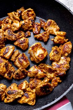 chicken is cooking in a skillet on the stove