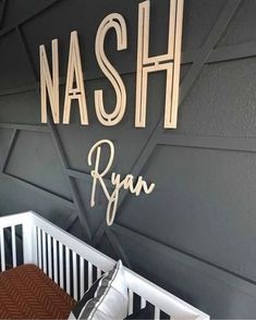 a baby's room with black and white walls, wooden letters on the wall