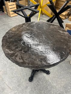 a round table sitting on top of a cement floor next to boxes and other items