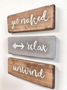 three wooden signs that say get naked, relax and unwind on the side of a wall