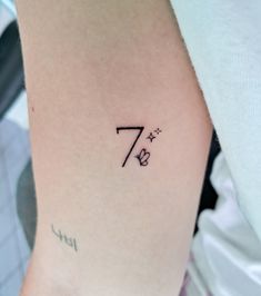 a woman's arm with the number seven tattoo on it