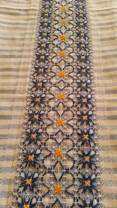 an intricately designed table runner with orange and blue flowers on it's edges