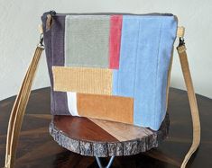 a multicolored purse sitting on top of a wooden table