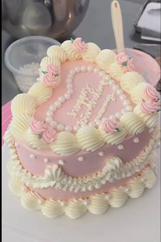 a pink and white cake sitting on top of a table