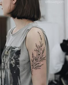 the back of a woman's arm with tattoos on it, and an image of flowers