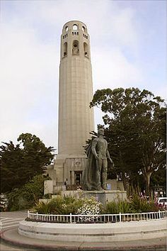 there is a statue in front of a tall tower