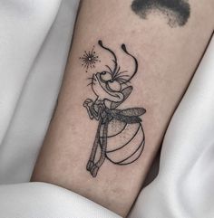 a black and white photo of a cartoon character tattoo on the left inner arm,