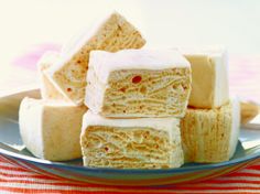 several pieces of cake sitting on top of a blue plate next to a red and white checkered table cloth