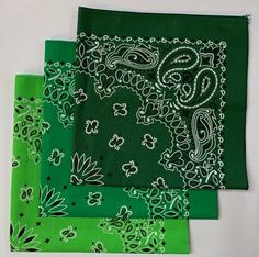 three green bandanas with white designs on them