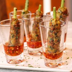 small glasses filled with food on top of a white tray