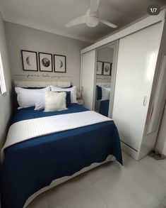 a bedroom with white and blue bedding and pictures on the wall above the bed