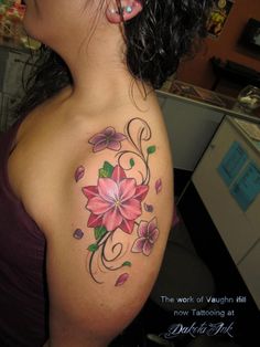 a woman with a flower tattoo on her shoulder