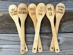 four wooden spoons with words on them are lined up next to each other,