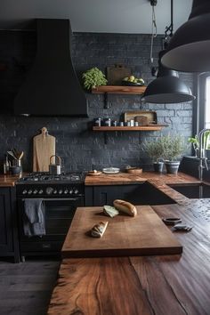 a kitchen with black walls and wooden counter tops, an oven hood over the stove