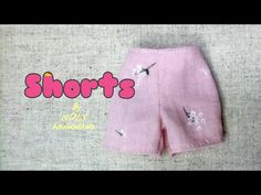 a pink shorts with white flowers on the bottom and an image of a bird flying over it