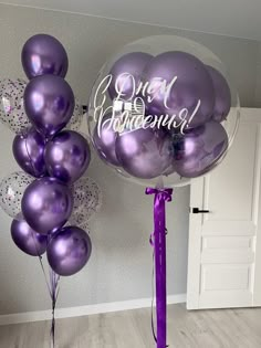 purple balloons with the words congratulations on them in front of a white wall and door