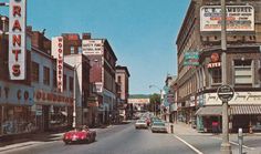 an old photo of cars driving down the street