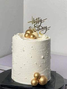 a white cake with gold decorations on top