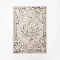 an old rug hanging on the wall in front of a white wall with a wooden floor