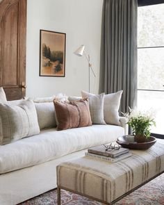 a living room filled with lots of furniture and pillows on top of a white couch