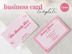 two pink business cards sitting on top of a white towel