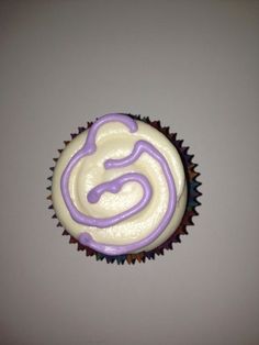 a cupcake with white frosting and purple icing